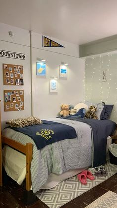 a bed room with a neatly made bed and stuffed animals on the wall next to it