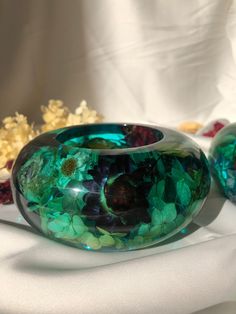 two glass vases sitting on top of a white tablecloth covered table next to popcorn