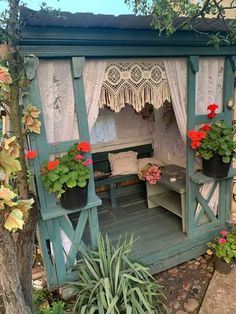 an outdoor gazebo with potted plants and flowers