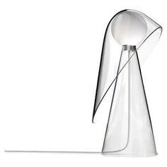 a glass table lamp with a white light on it's side and an object in the middle