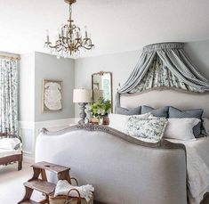 a bedroom with a large bed and chandelier