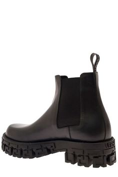 Elevate your style with the GRECA PORTICO Chelsea Boots by Versace. Crafted in smooth leather, these ankle boots are a luxurious addition to any wardrobe. The thick rubber lug sole featuring the iconic Greca pattern adds a touch of elegance to the edgy design. With side elastic inserts, logoed back pull, and a leather interior, these boots offer both comfort and style, making them the perfect choice for fashion-forward individuals. Smooth leather construction Thick rubber lug sole with Greca pat Luxury Ankle Moto Boots With Lug Sole, Luxury Ankle Combat Boots With Lug Sole, High-top Calf Leather Boots For Streetwear, Black Calf Leather Boots For Streetwear, Streetwear Ankle Platform Boots With Leather Sole, Black Chelsea Boots With Lug Sole In Calf Leather, Black Calf Leather Chelsea Boots With Lug Sole, Streetwear Boots With Calf Leather And Leather Sole, Luxury Chelsea Boots With Lug Sole In Calf Leather