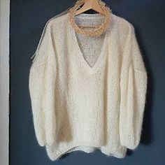 a white sweater hanging on a blue wall