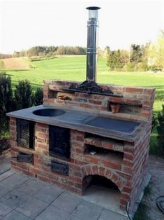 an outdoor brick pizza oven in the middle of a field