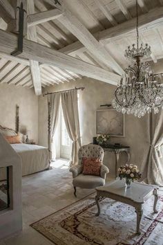 a bedroom with a chandelier hanging from the ceiling next to a couch and chair