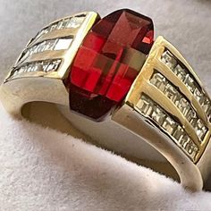 Over 6 carats of fancy cut Spessartite Garnet set in 14kt. yellow gold accented with 48 SI diamonds. One of a kind. This ring has the Wow factor.  You look at it and say Wow! The gem, diamonds and gold are all 100% genuine. The gem sits in a channel setting. The gem has rich saturation and the diamonds sparkle out loud. Perfect engagement or statement ring. Spessartite Garnet, Garnet Gem, Channel Setting, Gem Diamonds, Garnet Ring, Red Band, Diamonds And Gold, Star Ring, Garnet Rings