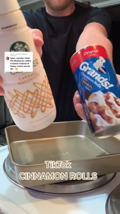 a man is holding up a can of cinnamon rolls and a bottle of coffee in front of him