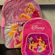 two backpacks with princesses on them sitting next to each other