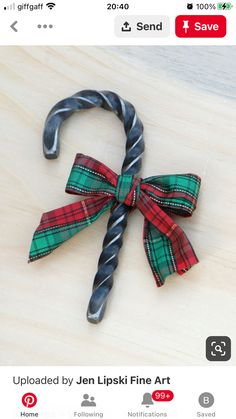 a candy cane with a plaid bow on it's end sitting on a table