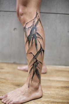 a man's leg with bamboo leaves on it