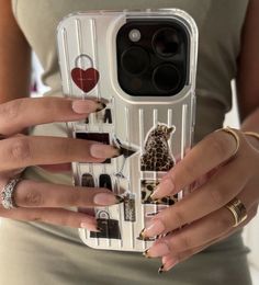 a woman holding up her phone case with different nail designs on it and two hands