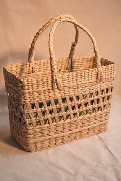 a wicker basket sitting on top of a white sheet