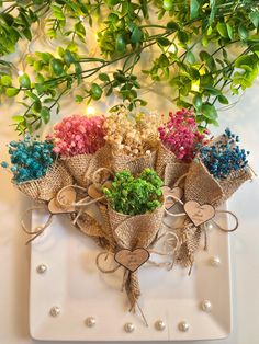 a bunch of flowers sitting on top of a white plate with burlocks and hearts