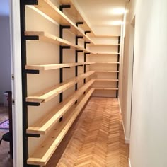 an empty walk in closet with wooden shelves and black brackets on the bottom half of it