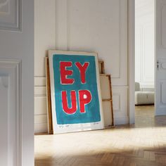 an eye up sign sitting on top of a hard wood floor next to a doorway