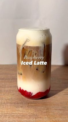 an iced latte in a glass on a wooden table with the label raspberry iced latte