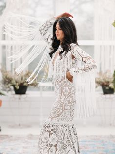 a woman in a white dress is posing for the camera