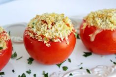 three tomatoes with crumbs on them sitting on a plate