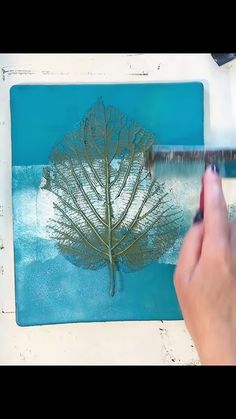 a person is painting a tree with blue paint