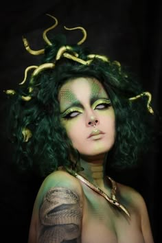 a woman with green hair and tattoos on her body is posing for a photo in front of a black background