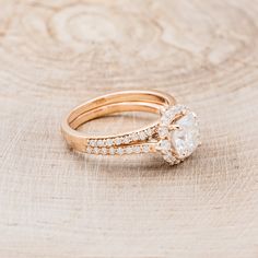 two gold wedding rings with diamond accents on wooden background, close up view from the side