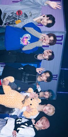 the group of young people are posing with their teddy bear in front of an empty box