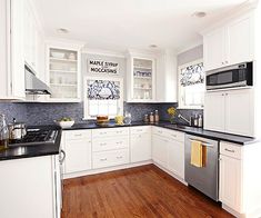 a kitchen with white cabinets and black counter tops is pictured in this image from the front view