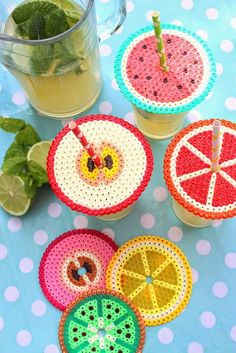 crocheted coasters with fruit on them sitting next to a cup of tea