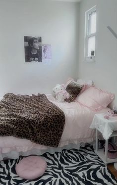 a bedroom with a zebra print rug and pink bedding