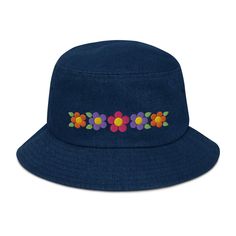 Puff Embroidered Three Daisy Denim Bucket Hat with orange daisies, purple daisies, and one pink daisy with yellow centers. 100% Cotton. Poplin sweatband absorbs sweat. Practical, comfortable and fashionable hat. One size fits most. Gift for nature lovers, gardening, sun protection hat, and beach hat. Birthday gifts for women and gardeners. Made to order, ships in 2-7 days. Click and Order today to wear this springtime and summertime! Here's an accessory that'll become your main outfit piece. Get yourself this trendy, comfortable, and versatile bucket hat that'll work for all kinds of outfits--casual, sporty, and streetwear. * 100% cotton * 2 sewn eyelets on each side of the hat * Poplin sweatband * One size fits most * Blank product sourced from China For other daisy hats and gifts click h Cute Blue Bucket Hat For Spring, Casual Flower-shaped Sun Hat For Summer, Casual Flower Shaped Sun Hat For Summer, Casual Summer Sun Hat With Flower Shape, Blue Cotton Sun Hat For Spring, Retro Blue Bucket Hat For Summer, Cute Multicolor Sun Hat For Spring, Fun Cotton Hats For Spring, Retro Cotton Sun Hat For Summer