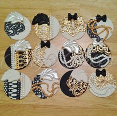 many different types of brooches are shown on a wooden table with black and white accents