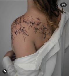 the back of a woman's shoulder with flowers tattooed on her left arm and chest