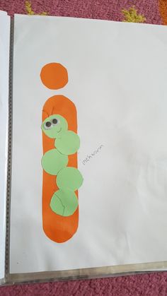 a child's drawing of a letter j with an orange and green caterpillar on it