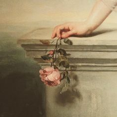 a painting of a person's hand holding a rose on top of a pillar