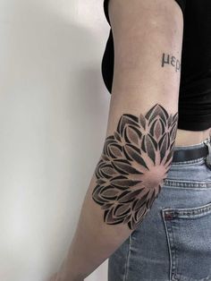 a woman's arm with a flower tattoo on the left side of her arm