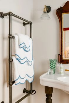 a bathroom with a sink, mirror and towel rack