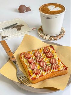 a piece of pizza on a plate next to a cup of coffee