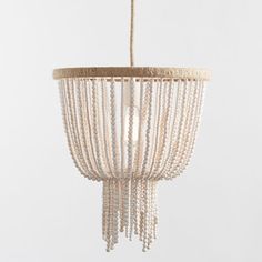 a white chandelier with beads hanging from it's sides and a light fixture in the middle