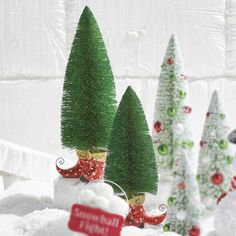 small christmas trees are sitting in the snow