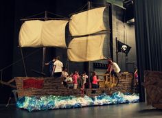 people are standing on a pirate ship in a museum