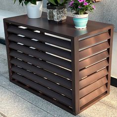 two potted plants sitting on top of a wooden box