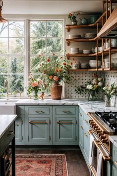 a kitchen filled with lots of green cabinets and white counter tops next to a window