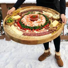 a person standing in front of a platter filled with food