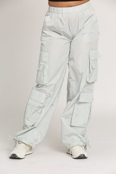 NEW Limited Edition & custom designed Ice Grey Parachute Pants! Not only did we spend months designing these amazing cargo style pants, but we PERFECTED them in the process! These pants are insanely versatile due to their lightweight material and trendy style. They feature adjustable ankle cuffs that you can leave wide or tie up for a jogger look. The elastic waist-band allows for a comfortable fit and the multiple pockets provide great functionality. These pants easily can be worn for any worko Nylon Wide Leg Parachute Pants With Cargo Pockets, Nylon Wide Leg Cargo Parachute Pants, Full-length Cargo Parachute Pants In Techwear Style, Wide Leg Nylon Parachute Pants With Cargo Pockets, Full-length Cargo Style Techwear Parachute Pants, Full Length Techwear Cargo Parachute Pants, Full Length Cargo Style Techwear Parachute Pants, Outdoor Full-length Parachute Pants With Cargo Pockets, Full Length Outdoor Parachute Pants With Cargo Pockets