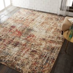 an area rug in a living room with wood flooring and brick wall behind it