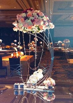 a table topped with lots of flowers on top of a glass table covered in lights