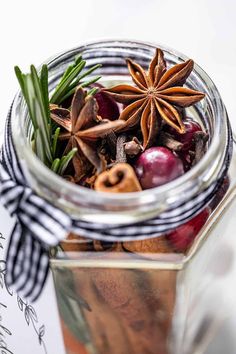 a jar filled with spices and anise on top of a table