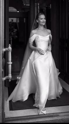 a woman in a wedding dress standing on the steps