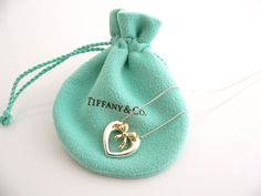 Overview:Here is an awesome Tiffany necklace that you will surely wear over and over again! Offered for sale is a vintage and very pretty Tiffany & Co. Sterling Silver & 18K Gold Heart Ribbon necklace.  Classic and elegant piece!  The piece is very versatile and will most certainly go perfectly with other pieces of jewelry that you already own.  It is a wonderful necklace that fits a lifestyle on the go -- the necklace can be worn to almost any occasion! And because it is two tone, it wi Tiffany Elsa Peretti, Sapphire Heart Necklace, Heart Ribbon, Open Heart Necklace, Tiffany Necklace, Oval Necklace, Ribbon Necklace, Bow Necklace, Dior Jewelry