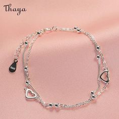 Design concept     The slender double-layered chain is lovely. The hollow love heart and round beads add a sweet touch, wrapping around the wrist and highlighting the slender and white wrist. How can spring outfits be missing this touch of sweetness, which will show delicate and soft beauty and charming temperament.     Detail    Brand: Thaya  Material: 925 Silver + oxidation  Gender:Female  Size: Chain length about 15+3cm extension chain, love about 0.9cm  Weight: About 1.78g Elegant Double Chain Charm Bracelet, Trendy Silver Bracelets With Heart Beads, Trendy Silver Heart Beads Bracelet, Elegant Heart Jewelry For Spring, Elegant Heart Shaped Jewelry For Spring, Elegant Heart-shaped Jewelry For Spring, Double Heart Bracelet With Adjustable Chain, Trendy Silver Charm Bracelet With Heart Beads, Trendy Heart-shaped Jewelry For Spring